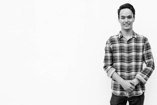 Young handsome Indian man against white wall outdoors in black and white — Stock Photo, Image