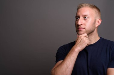 Studio shot of man with blond hair against gray background