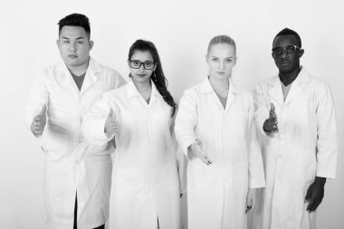 Çok etnik doktor el sıkışma birlikte veren çeşitli grup stüdyo çekim