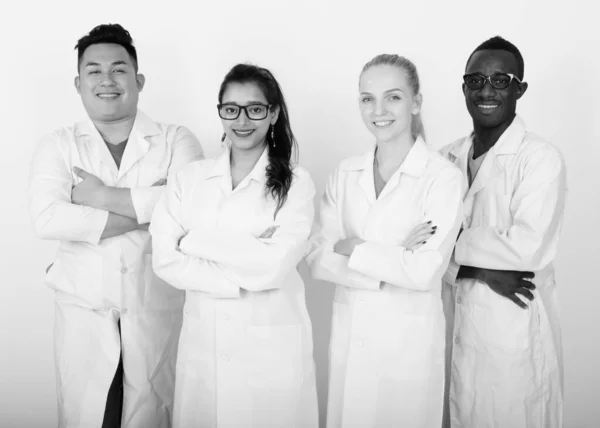 Studio skott av glad mångskiftande grupp av multi etniska läkare leende med armarna korsade tillsammans — Stockfoto