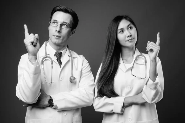 Retrato de dos jóvenes médicos multiétnicos juntos en blanco y negro —  Fotos de Stock
