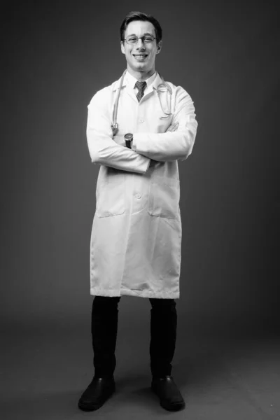 Joven hombre guapo médico sobre fondo gris en blanco y negro —  Fotos de Stock