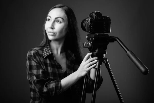 Studio shot van jong mooi hipster vrouw vlogging in zwart-wit — Stockfoto
