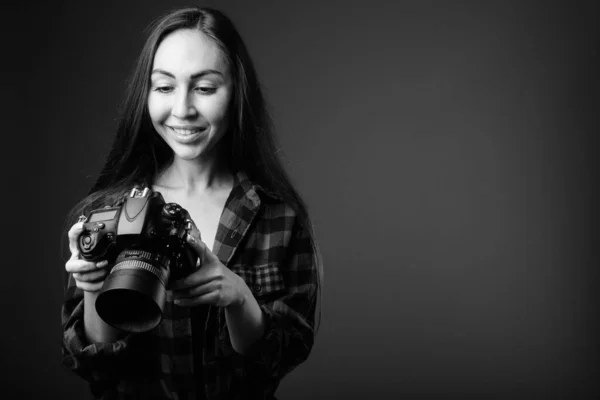 Studio shot van jonge mooie hipster vrouw met camera in zwart-wit — Stockfoto