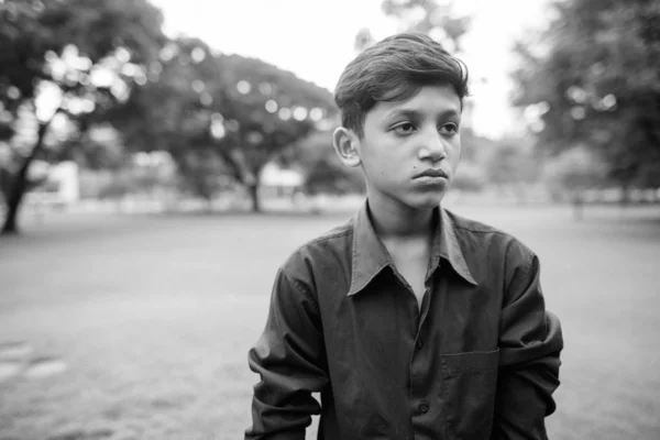 Portrét mladého indického chlapce relaxační v parku — Stock fotografie