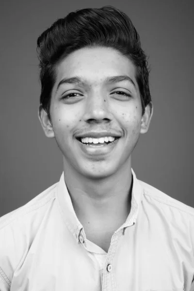 スタジオショットの若いですインドの男の子見ますスマートに対してグレー背景で黒と白 — ストック写真