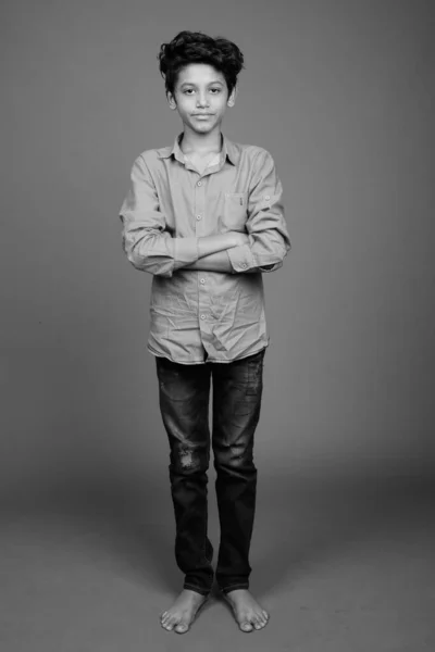 Young Indian boy wearing smart casual clothing against gray background