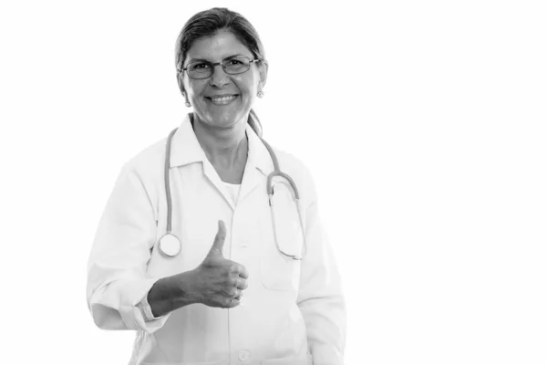 Estúdio tiro de mulher feliz madura médico sorrindo ao dar o polegar para cima — Fotografia de Stock