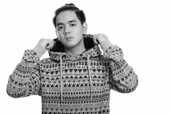 Studio shot of young handsome Asian man holding hoodie — Φωτογραφία Αρχείου