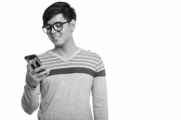Studio πυροβολισμό ευτυχισμένη Ασίας νεαρού χαμογελώντας ενώ χρησιμοποιώντας το κινητό τηλέφωνο — Φωτογραφία Αρχείου