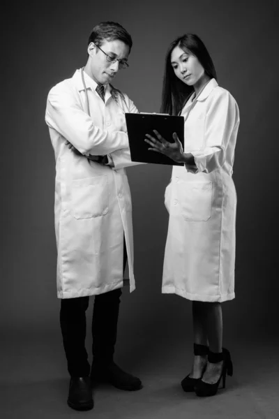Retrato de dos jóvenes médicos multiétnicos juntos en blanco y negro —  Fotos de Stock