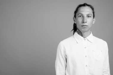 Siyah-beyaz gri arka planda rastalı genç iş adamının stüdyo fotoğrafı.