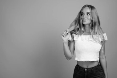 Stüdyo çekimlerinde, sarı saçlı, siyah beyaz arka planda güzel bir kadın vardı.