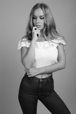 Stüdyo çekimlerinde, sarı saçlı, siyah beyaz arka planda güzel bir kadın vardı.