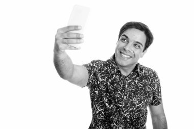 Beyaz arka planda siyah ve beyaz olarak izole edilmiş yakışıklı İranlı adamın stüdyo fotoğrafı.