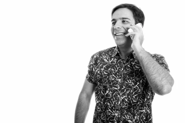Зйомки молодого щасливого перського чоловіка, який посміхається і думає під час розмови по мобільному телефону ізольовано від білого походження — стокове фото