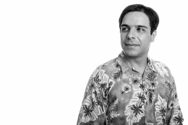 Estúdio tiro de jovem persa turista homem pensando enquanto vestindo camisa havaiana isolado contra fundo branco — Fotografia de Stock