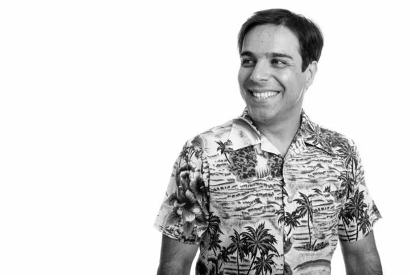 Studio shot de jeune touriste persan heureux souriant et pensant tout en portant une chemise hawaïenne — Photo