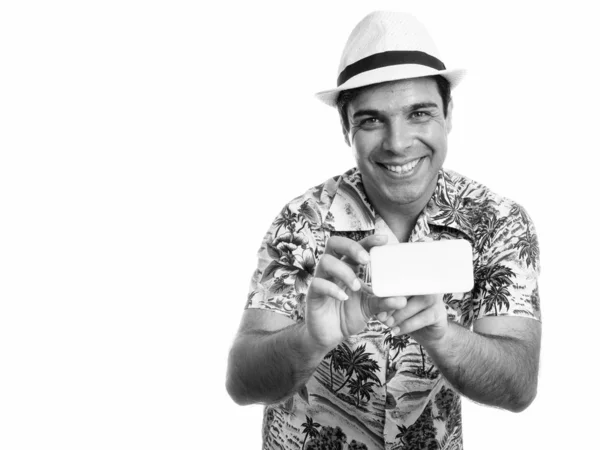 Estudio de tiro de joven feliz turista persa sonriendo mientras toma una foto con el teléfono móvil — Foto de Stock