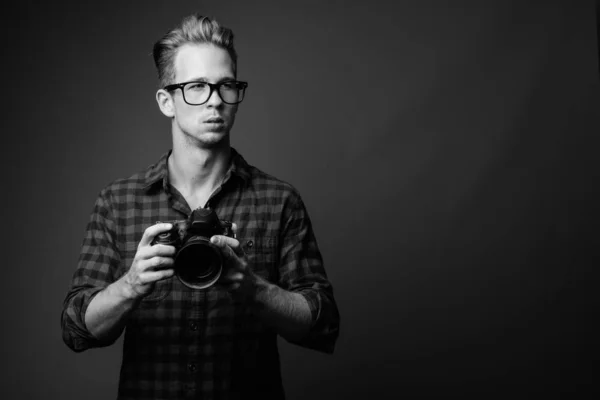 Jovem hipster bonito homem com câmera em preto e branco — Fotografia de Stock