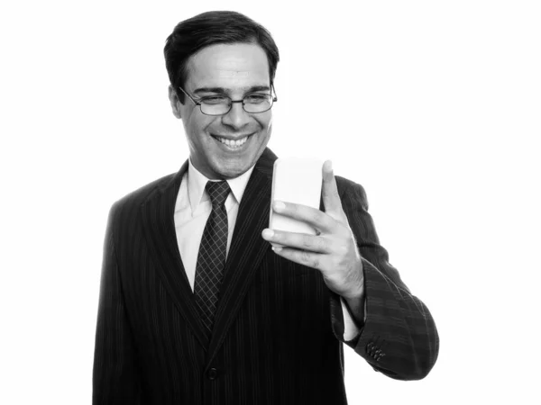 Στιγμιότυπο στούντιο του νεαρού ευτυχισμένου Πέρση επιχειρηματία χαμογελώντας ενώ χρησιμοποιεί το κινητό τηλέφωνο απομονώνονται σε λευκό φόντο — Φωτογραφία Αρχείου