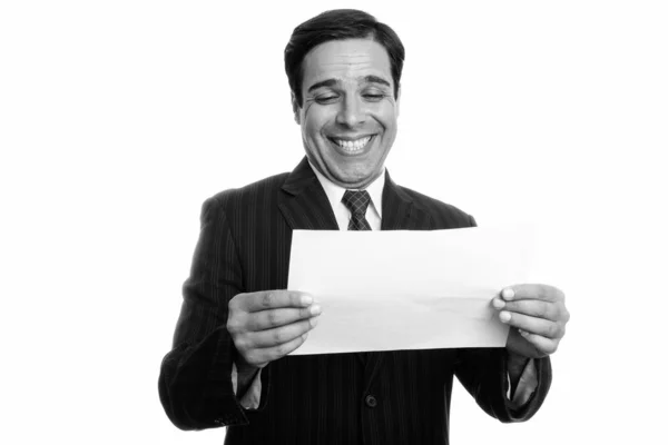 Estudio plano de joven feliz empresario persa sonriendo mientras lee en papel aislado sobre fondo blanco —  Fotos de Stock