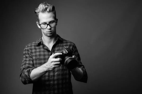 Jovem hipster bonito homem com câmera em preto e branco — Fotografia de Stock