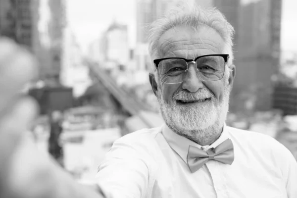 Stilig skäggig senior turist man utforska staden i svart och vitt — Stockfoto