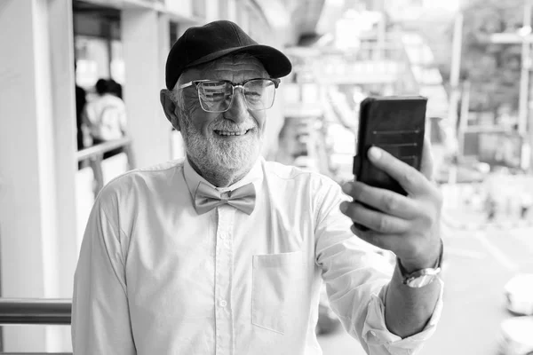 Stilig skäggig senior turist man utforska staden i svart och vitt — Stockfoto