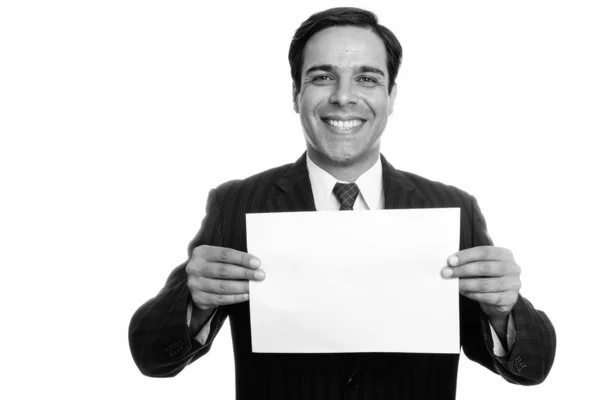 Estudio disparo de joven feliz empresario persa sonriendo mientras sostiene papel aislado sobre fondo blanco —  Fotos de Stock