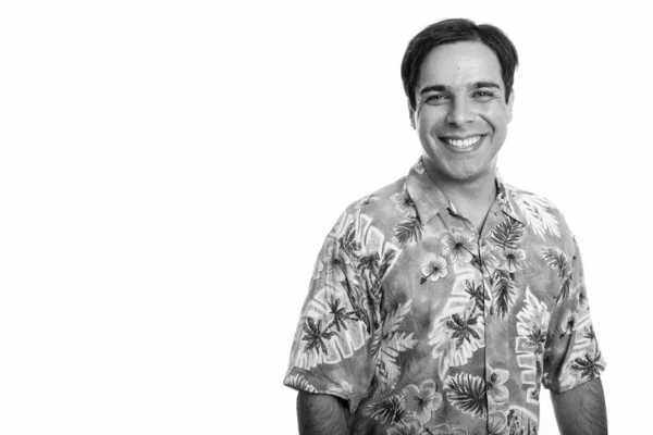 Studio shot de jeune touriste persan heureux souriant tout en portant chemise hawaïenne isolé sur fond blanc — Photo