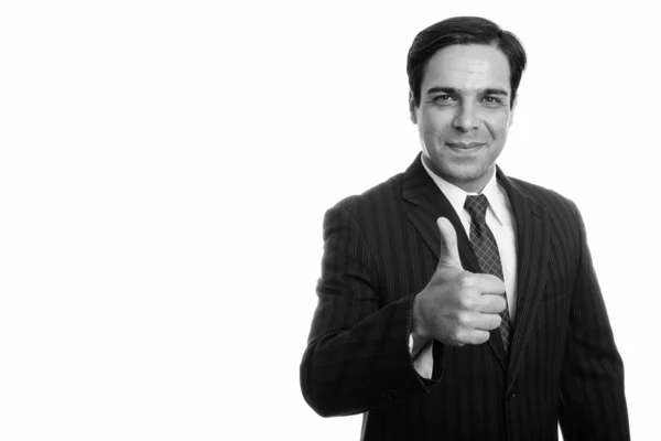 Studio shot of young Persian businessman giving thumb up isolated against white background — Stock Photo, Image