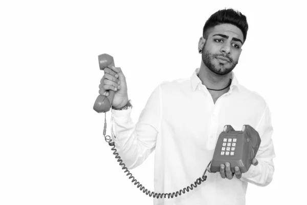 흰색 배경에 고립 된 전화를 잡고 화가 찾고 젊은 잘생긴 인도 남자의 스튜디오 샷 — 스톡 사진