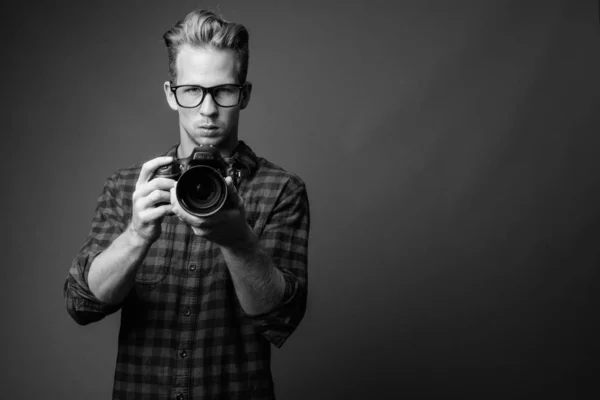 Jovem hipster bonito homem com câmera em preto e branco — Fotografia de Stock