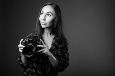 Siyah beyaz fotoğraf makinesi olan genç ve güzel bir hipster kadının stüdyo fotoğrafı.