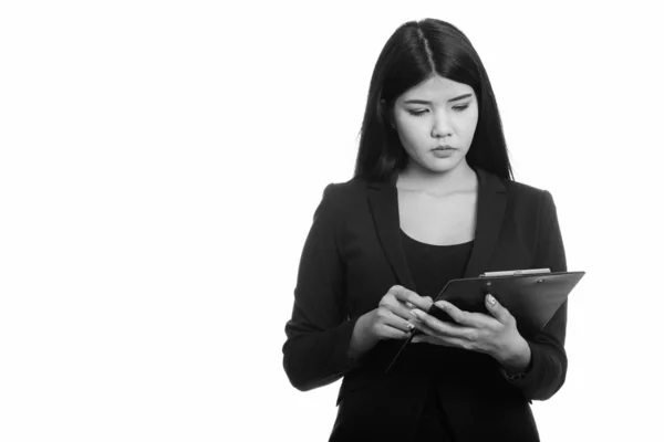 Studio shot de jeune femme d'affaires asiatique lecture sur presse-papiers — Photo