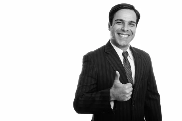 Studio shot of young happy Persian businessman smiling while giving thumb up isolated against white background — ストック写真