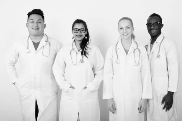 Estudio de feliz grupo diverso de médicos multiétnicos sonriendo y de pie juntos — Foto de Stock