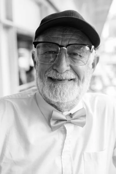 Yakışıklı, sakallı, yaşlı turist şehri siyah beyaz geziyor. — Stok fotoğraf