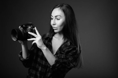 Siyah beyaz fotoğraf makinesi olan genç ve güzel bir hipster kadının stüdyo fotoğrafı.