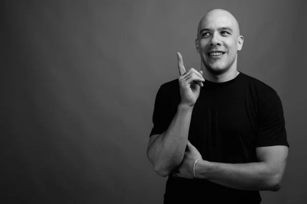 Handsome bald man against gray background in black and white — Stock Photo, Image
