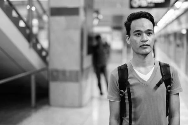 Jovem homem indiano bonito na estação de trem do metrô em preto e branco — Fotografia de Stock
