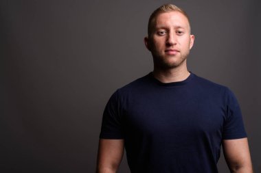 Man with blond hair against gray background