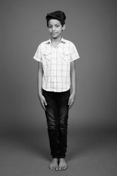Jovem indiana menino vestindo xadrez camisa contra cinza fundo — Fotografia de Stock