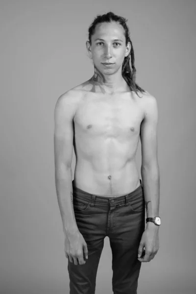 Νεαρός άνδρας χωρίς πουκάμισο με κοτσιδάκια σε μαύρο και άσπρο — Φωτογραφία Αρχείου