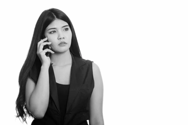 思いながら携帯電話で話している若いアジア女性のスタジオ撮影 — ストック写真