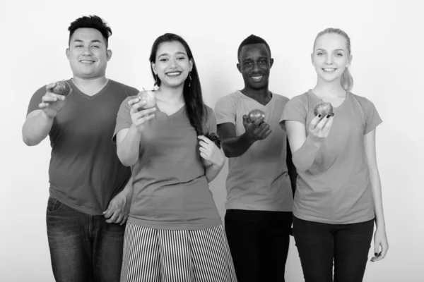 Studio shot van gelukkig diverse groep van etnische vrienden multi glimlachen terwijl het geven van rode appel samen — Stockfoto