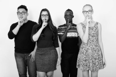 Stüdyo çekim gözlük birlikte giyen iken dudaklarında parmak ile çoklu etnik arkadaşlarından farklı grup