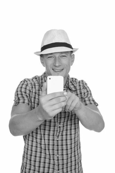 Estudio disparo de joven feliz hombre caucásico tomando foto con el teléfono móvil aislado sobre fondo blanco —  Fotos de Stock