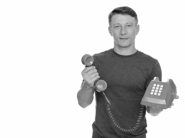 Студія вистрілив молодих красивий кавказьких людина даючи Старий червоний телефон ізольовані на білому тлі — стокове фото